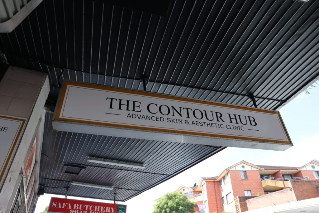 The Contour Hub Advanced Skin & Aesthetic Clinic exterior under-awning building sign located on Auburn Road.